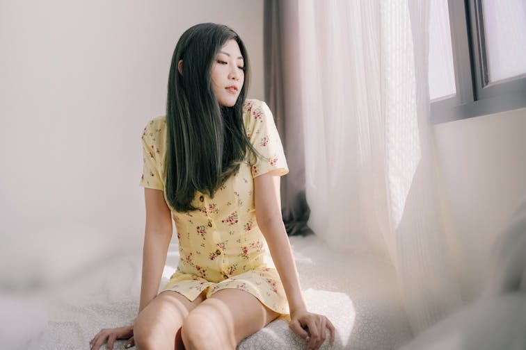 すべすべの脚の女性。明るい空間でリラックスしている、清潔感のあるイメージ写真