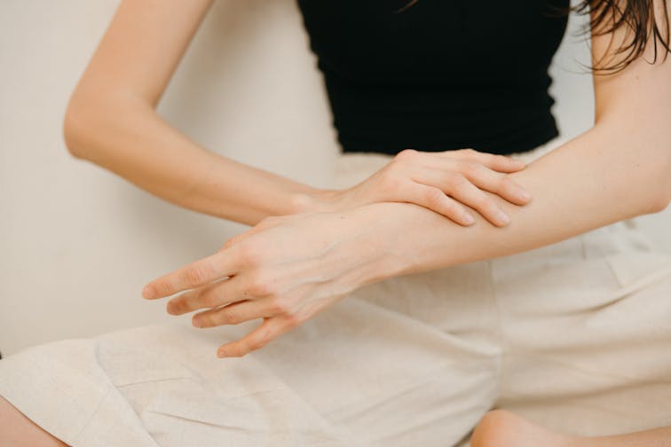すべすべの肌を触って確認している女性の手元。清潔感のある明るいイメージ